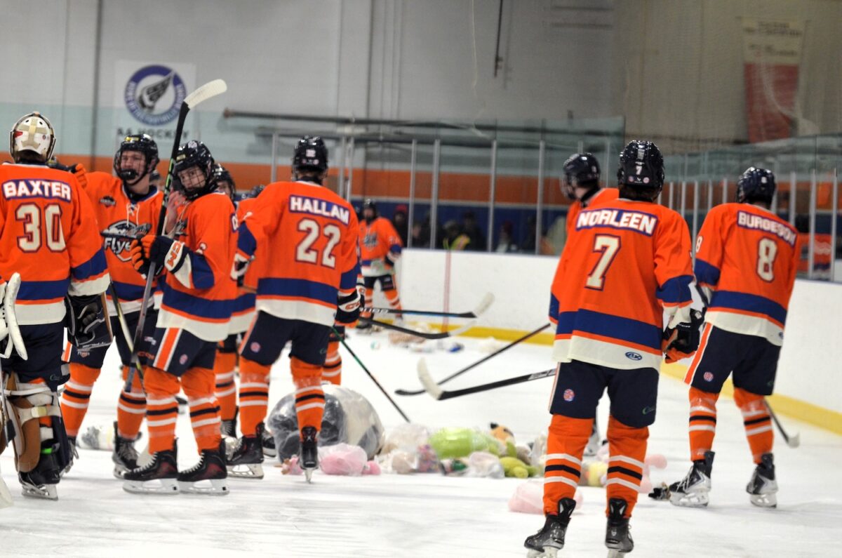 Flyers piling up teddy bears after they were thrown onto the ice. (Photo submitted)